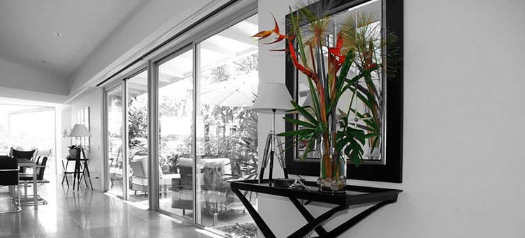 Blick durch Glasfront auf Wintergarten vor Essbereich mit Spiegel und Zierpflanzen - Putzfrau Hamburg-Grambek.